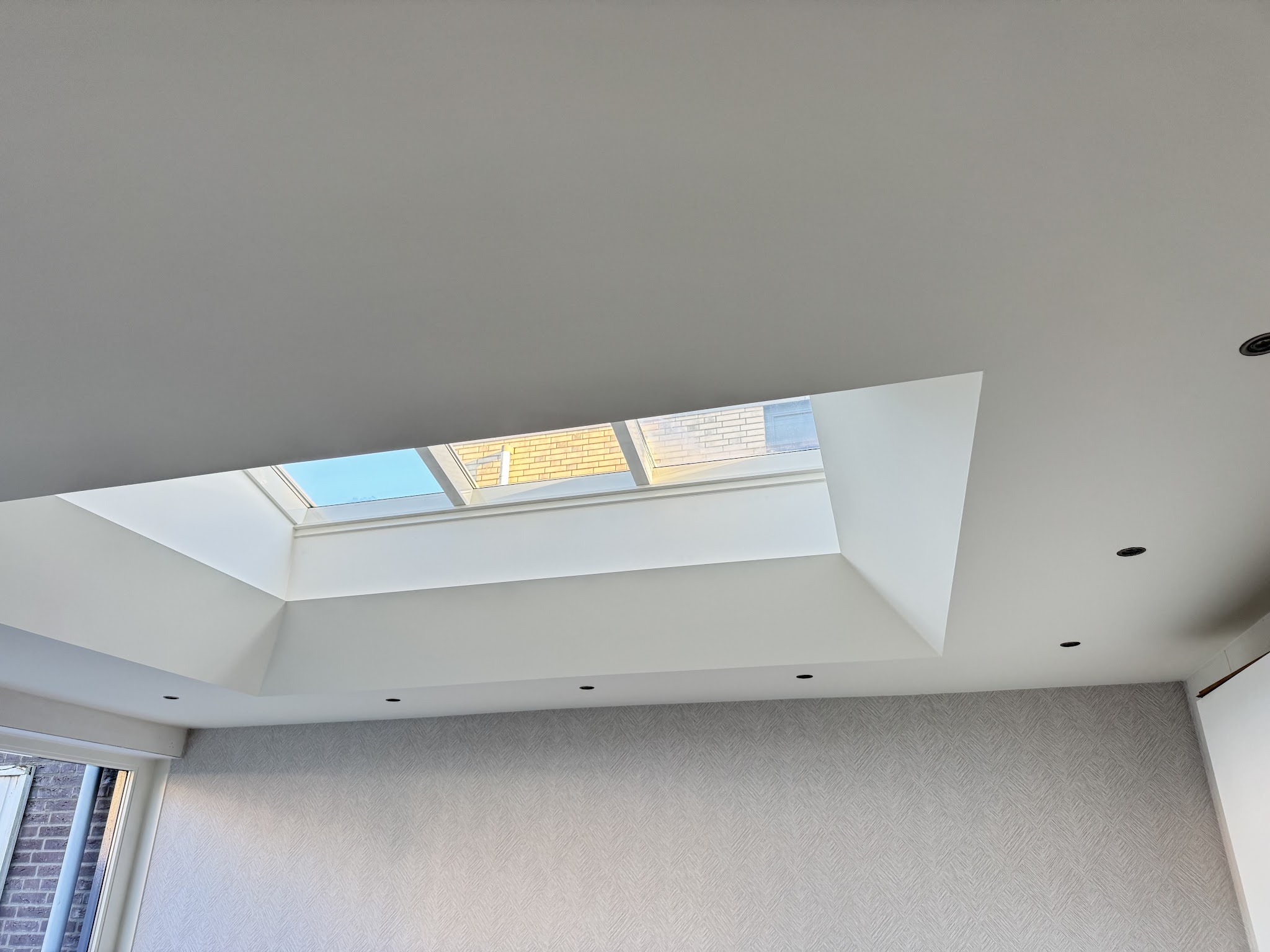 Wit plafond met een lichtkoepel en strakke hoeken