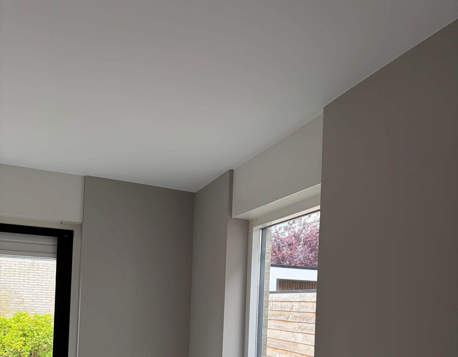 Kamer met taupe wanden, een wit plafond, een raam en een tuindeur